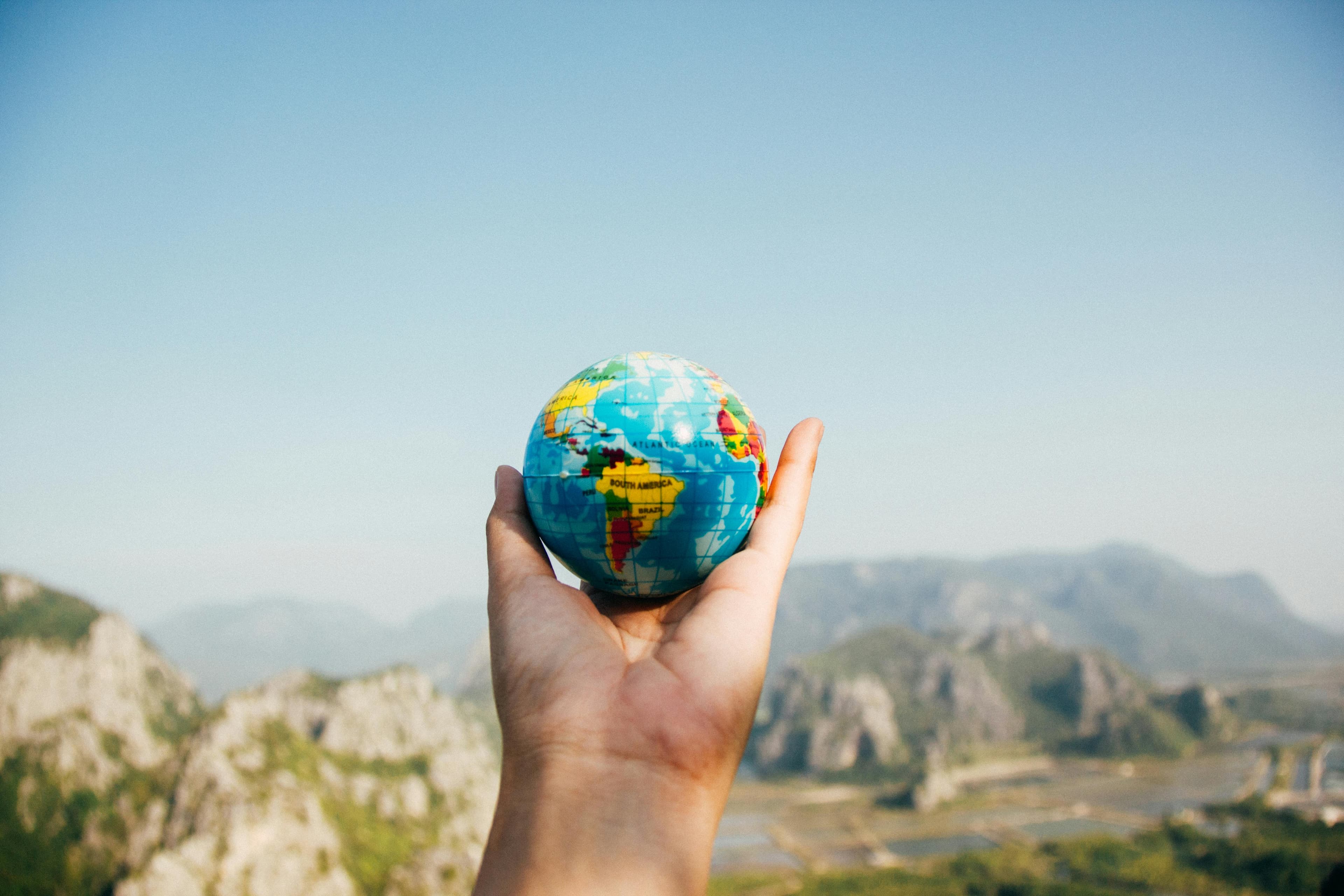 A person holding a world map, symbolizing global exploration and connectivity in a thoughtful gesture.